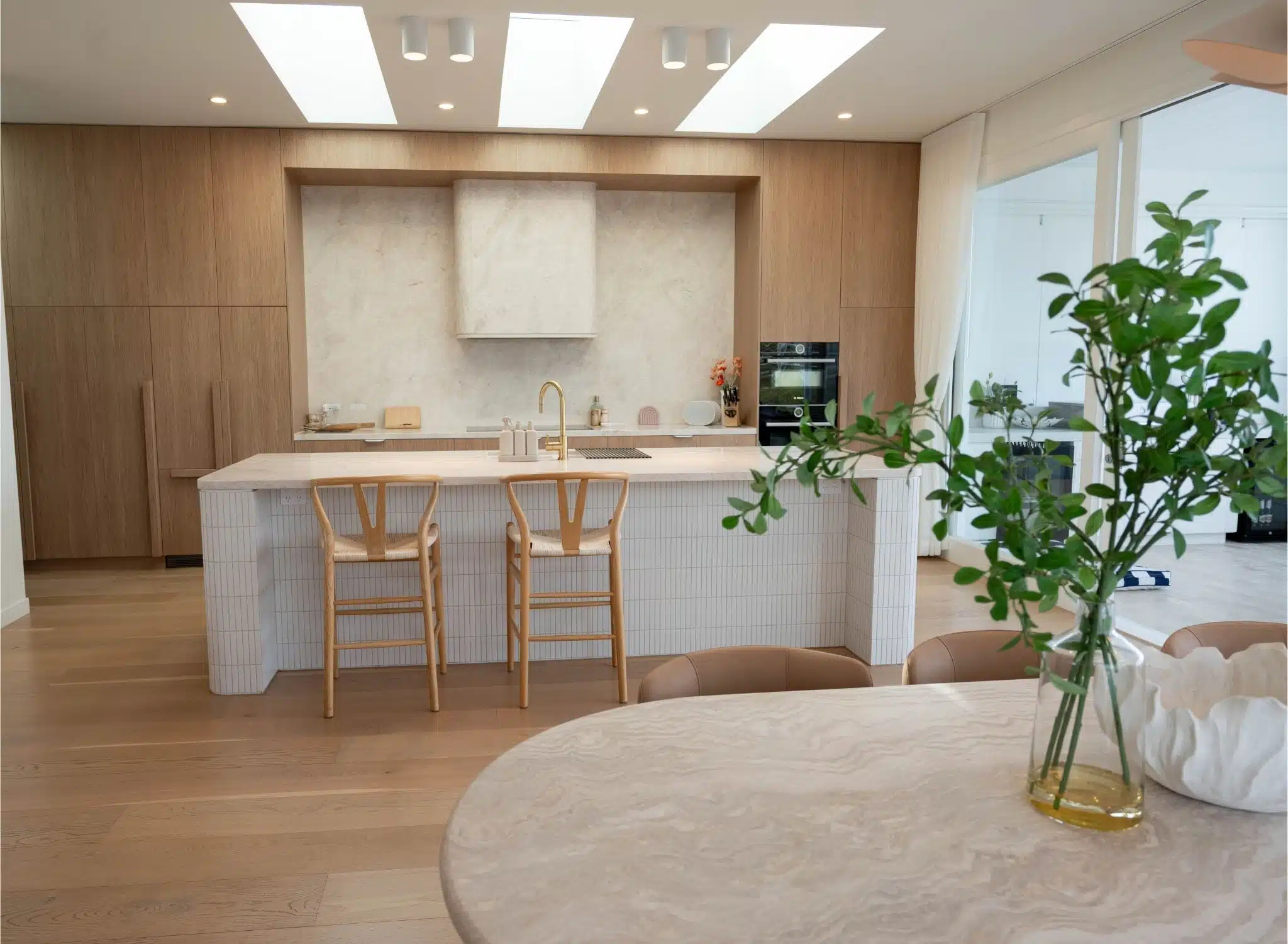 sleek modern kitchen featuring two black stools, showcasing contemporary design elements and a minimalist aesthetic.